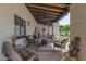 Covered outdoor patio with comfortable seating, ceiling fans and views of the landscaped backyard at 4617 E Elmwood Cir, Mesa, AZ 85205