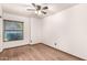 This bedroom features light walls and a ceiling fan, as well as hardwood flooring and a large window at 4901 S Vista Pl, Chandler, AZ 85248