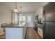 Well-lit kitchen featuring stainless steel appliances, an island, and wood laminate flooring at 5317 E Baltimore St, Mesa, AZ 85205
