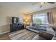 Comfortable living room features a cozy sofa, entertainment center, and large window at 5317 E Baltimore St, Mesa, AZ 85205