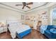 Charming bedroom features hardwood floors, a tray ceiling with fan, and a cozy sitting area by the window at 5523 W Creekside Ln, San Tan Valley, AZ 85144