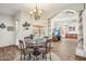 Cozy dining area with a round table, decorative chandelier, and views into the spacious living room at 5523 W Creekside Ln, San Tan Valley, AZ 85144