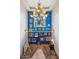 Unique hallway is decorated with framed memorabilia and features a bright chandelier at 5523 W Creekside Ln, San Tan Valley, AZ 85144