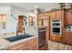 The kitchen has wood cabinetry, granite counters, stainless appliances, and tile floors at 5523 W Creekside Ln, San Tan Valley, AZ 85144