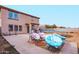 Backyard featuring a patio with seating, trampoline, and desert landscaping at 559 W Viola St, Casa Grande, AZ 85122