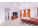 Spacious bedroom featuring neutral carpet, fan, and large windows with vibrant orange curtains at 559 W Viola St, Casa Grande, AZ 85122