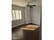 Sunlit bedroom with wood-look flooring, ceiling fan, and a large window at 600 S Dobson Rd # 53, Mesa, AZ 85202