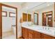 Bathroom features a double sink vanity, large mirror, and entry to a walk-in closet and shower area at 6122 E Harvard St, Scottsdale, AZ 85257