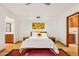 Bright bedroom features a queen bed, hardwood floors, and access to the bathroom and laundry area at 6122 E Harvard St, Scottsdale, AZ 85257