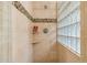 Tiled shower with glass block window, shower head and shelf at 6122 E Harvard St, Scottsdale, AZ 85257
