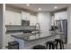 Contemporary kitchen featuring granite countertops, stainless steel appliances, and modern stools at 6732 W Pedro Ln, Laveen, AZ 85339