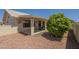 Backyard patio area with red rock landscaping and mature tree at 7925 E Monte Ave, Mesa, AZ 85209