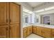Bathroom featuring dual sinks, wooden cabinets and a skylight for natural lighting at 7925 E Monte Ave, Mesa, AZ 85209