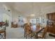 The dining room features a wooden table with seating for six and an open floorplan to the living room at 7925 E Monte Ave, Mesa, AZ 85209