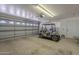 Spacious garage with a golf cart parked inside, featuring an open door and concrete floor at 7925 E Monte Ave, Mesa, AZ 85209