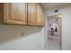 Hallway with white tiled floors and wooden upper cabinets leading to living space at 7925 E Monte Ave, Mesa, AZ 85209