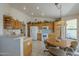 Bright kitchen features wood cabinets, white appliances, breakfast nook, and easy access to the outdoors at 7925 E Monte Ave, Mesa, AZ 85209