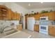 Spacious kitchen featuring ample counter space, white appliances and beautiful oak cabinets at 7925 E Monte Ave, Mesa, AZ 85209