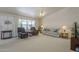 Relaxing living room features neutral colors, carpeted flooring, ceiling fan, and a large window for ample natural light at 7925 E Monte Ave, Mesa, AZ 85209
