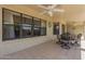 Cozy covered patio featuring a ceiling fan, a dining set, and windows overlooking the backyard at 7925 E Monte Ave, Mesa, AZ 85209