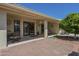 Covered patio with ceiling fan and tile flooring leading to additional brick paver area, providing ample space at 7925 E Monte Ave, Mesa, AZ 85209
