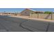 A street view showing the side of the property with desert landscaping and block wall at 7925 E Monte Ave, Mesa, AZ 85209