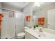 Well-lit bathroom featuring a glass-enclosed shower and a white vanity with orange towels at 8405 W Utopia Rd, Peoria, AZ 85382
