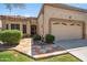 Inviting single-story home featuring a two-car garage, desert landscaping, and a tiled walkway at 8405 W Utopia Rd, Peoria, AZ 85382
