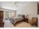 Bright main bedroom featuring a ceiling fan, neutral carpet, and a cozy window nook at 8405 W Utopia Rd, Peoria, AZ 85382