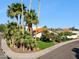 View of desert landscaping with a tile roof on a home and mature palm trees at 8719 E San Marcos Dr, Scottsdale, AZ 85258