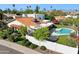 Lush backyard with a swimming pool, tile roof home, mature desert landscaping, and white walls at 8719 E San Marcos Dr, Scottsdale, AZ 85258