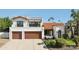 Elegant two-story home featuring a clay tile roof, lush landscaping, and a spacious three-car garage at 8719 E San Marcos Dr, Scottsdale, AZ 85258