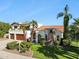 Elegant two-story home with a red tile roof, lush landscaping, and a spacious two-car garage at 8719 E San Marcos Dr, Scottsdale, AZ 85258