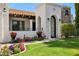Charming home entrance with a decorative iron gate, well-kept lawn, and vibrant floral accents at 8719 E San Marcos Dr, Scottsdale, AZ 85258
