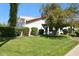 Picture of a lush front lawn with mature desert landscaping and a glimpse of the property's architecture at 8719 E San Marcos Dr, Scottsdale, AZ 85258