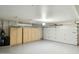 Garage with epoxy flooring, storage, and automatic door at 8719 E San Marcos Dr, Scottsdale, AZ 85258