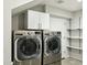 Laundry room with front load washer and dryer and storage cabinets at 8719 E San Marcos Dr, Scottsdale, AZ 85258