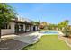 A refreshing kidney-shaped pool with artificial turf, covered patio, and mature landscaping at 8719 E San Marcos Dr, Scottsdale, AZ 85258