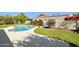 A kidney-shaped pool is surrounded by concrete and artificial turf, along with white walls for privacy at 8719 E San Marcos Dr, Scottsdale, AZ 85258