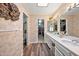 Well lit bathroom features a double vanity, wood floors, and a view into the walk-in closet at 9019 N 87Th Way, Scottsdale, AZ 85258