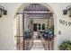Inviting courtyard with shaded pergola, seating, and wrought-iron gate, creating a cozy outdoor living space at 9019 N 87Th Way, Scottsdale, AZ 85258