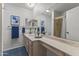 Well-lit bathroom with a long vanity, mirrors, and a shower stall, complete with blue floor tiles at 9202 N 107Th Ave, Sun City, AZ 85351