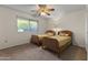 Bright bedroom with twin beds, a window overlooking the yard, and neutral carpeting at 9202 N 107Th Ave, Sun City, AZ 85351