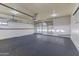 Large garage with painted floor, ample space, utility sink, and multiple entry points at 9202 N 107Th Ave, Sun City, AZ 85351
