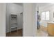 Hallway view showing a walk-in closet with shelves and a nearby bathroom with a shower at 9202 N 107Th Ave, Sun City, AZ 85351