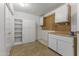 Spacious storage room with built-in shelving, cabinets, countertop, and pegboard wall at 9202 N 107Th Ave, Sun City, AZ 85351