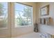 Bathroom featuring a soaking tub, a large window with natural light, and decorative accents at 10655 N 9Th St # 115, Phoenix, AZ 85020