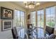Dining room with chandelier, glass-top table, and views of the outdoors from large windows at 10655 N 9Th St # 115, Phoenix, AZ 85020