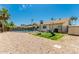 Fully fenced backyard with rock landscaping, mature trees, and playground at 1240 E Indigo St, Mesa, AZ 85203