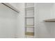 Walk-in closet with built-in shelving and wooden rods for hanging clothes at 1240 E Indigo St, Mesa, AZ 85203